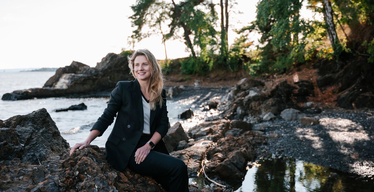 Marta sitting on a rock in the ocean