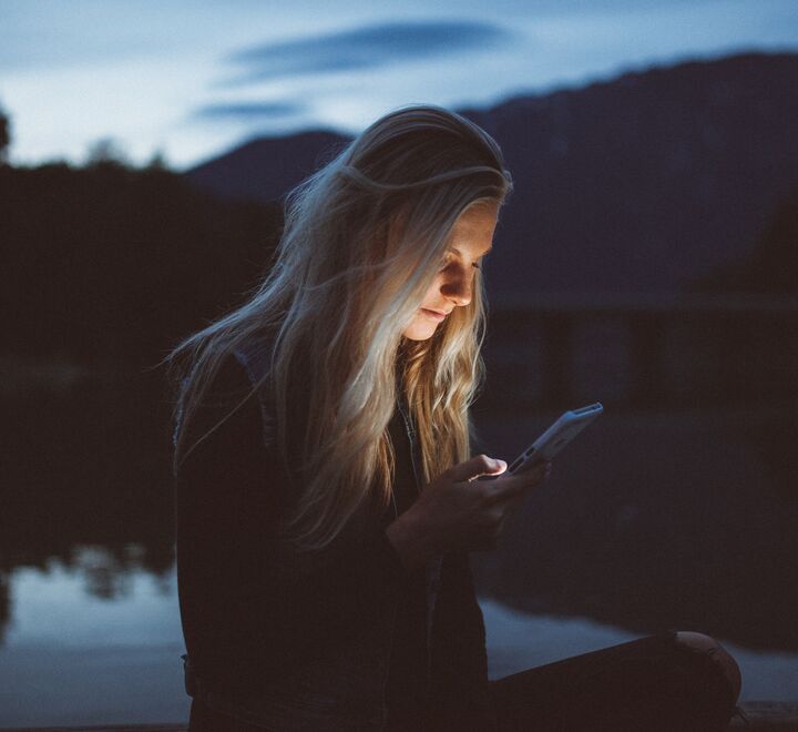 Koen Pauwels har analysert app-priser (kvinne på telefonen avbildet) for å finne ut hva det er som får kunder til å kjøpe. Foto: Becca Tapert (unsplash)