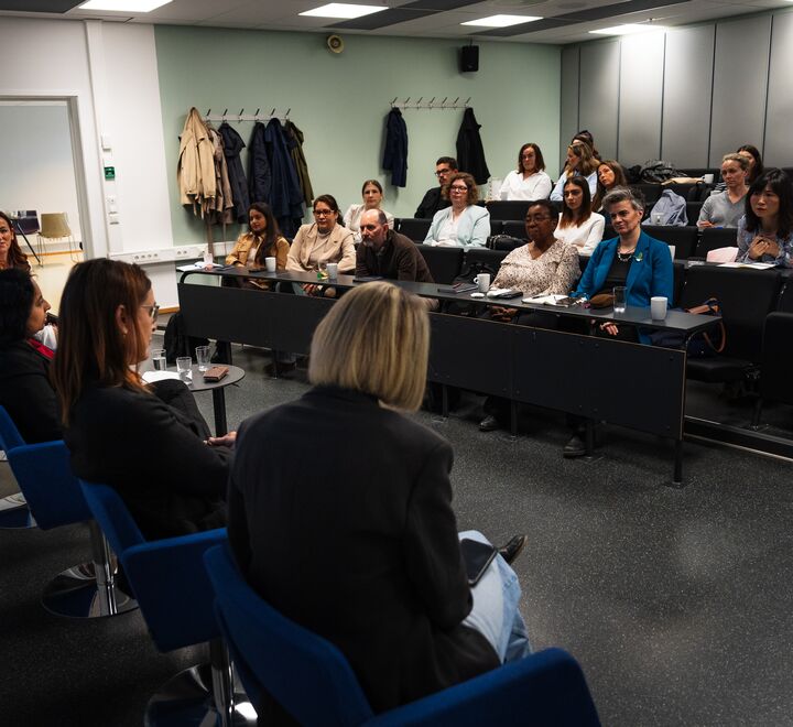 Behind the penal discussants, image of the audience