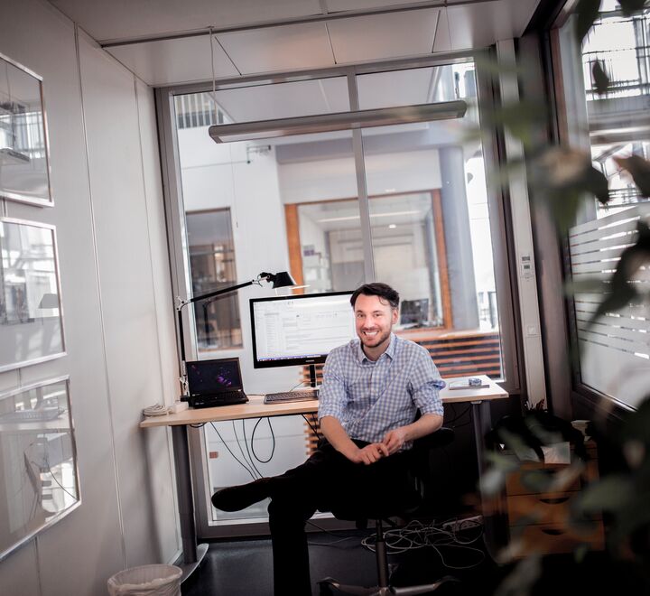A man smiling at his desk