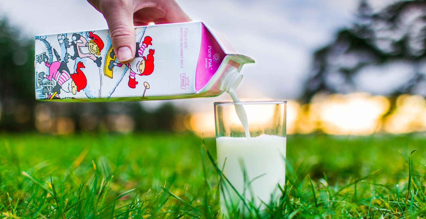 Illustrasjonsbilde av Tine melk på et grønt jorde. Foto: Bo Mathisen.