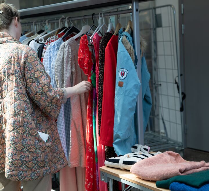 A woman looking at clothes at the second-hand market in Spring 2024