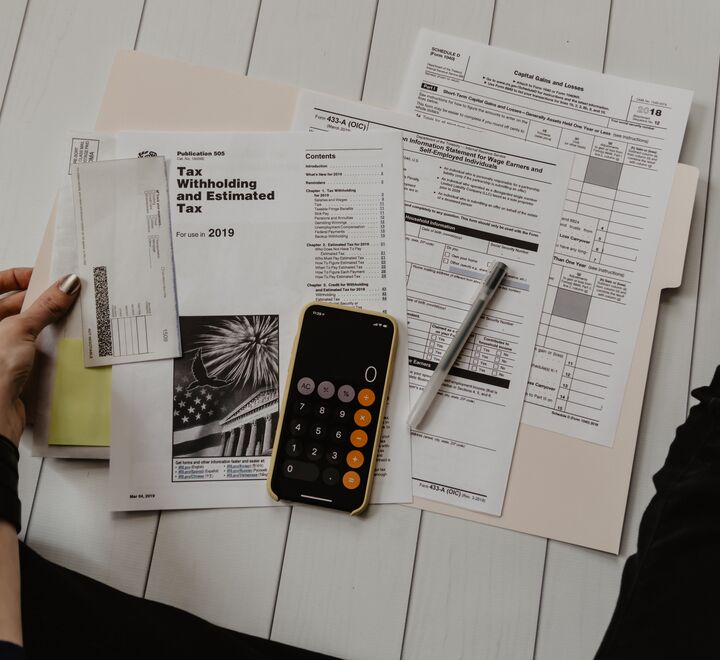 Formuesskatt gir to uheldige vridninger, og derfor er samfunnsøkonomer internasjonalt gjerne skeptiske til formuesskatt, skriver artikkelforfatterne. Her illustrert ved en dame som holder på med skattepapirer. (Foto: Kelly Sikkema, Unsplash.com)