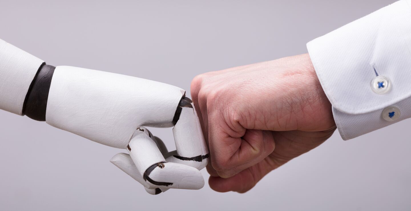 Robot And Human Hand Making Fist Bump On Grey Background.
