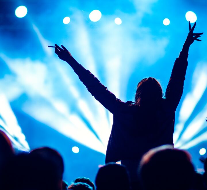 Person på konsert med armene over hodet