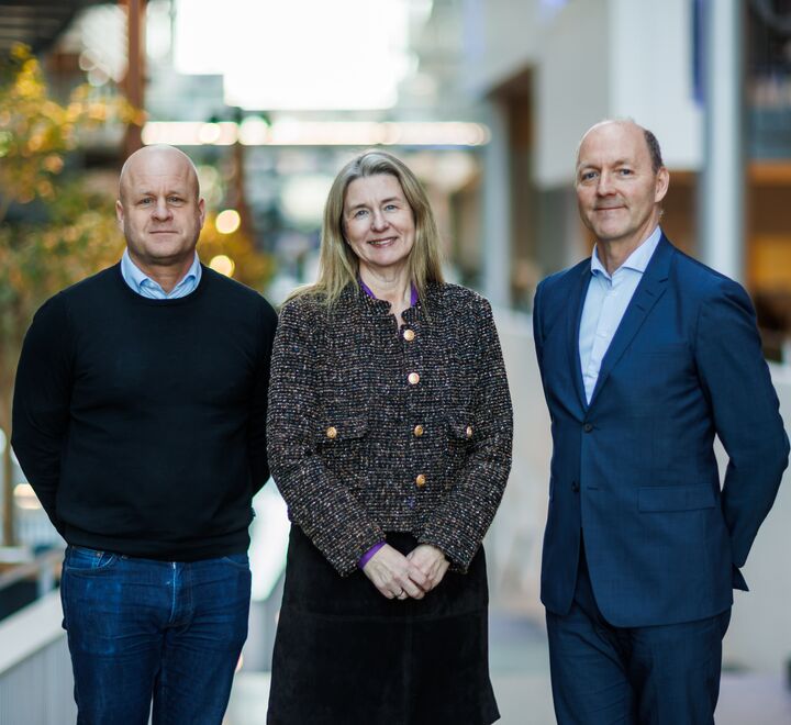 Tre mennesker som smiler