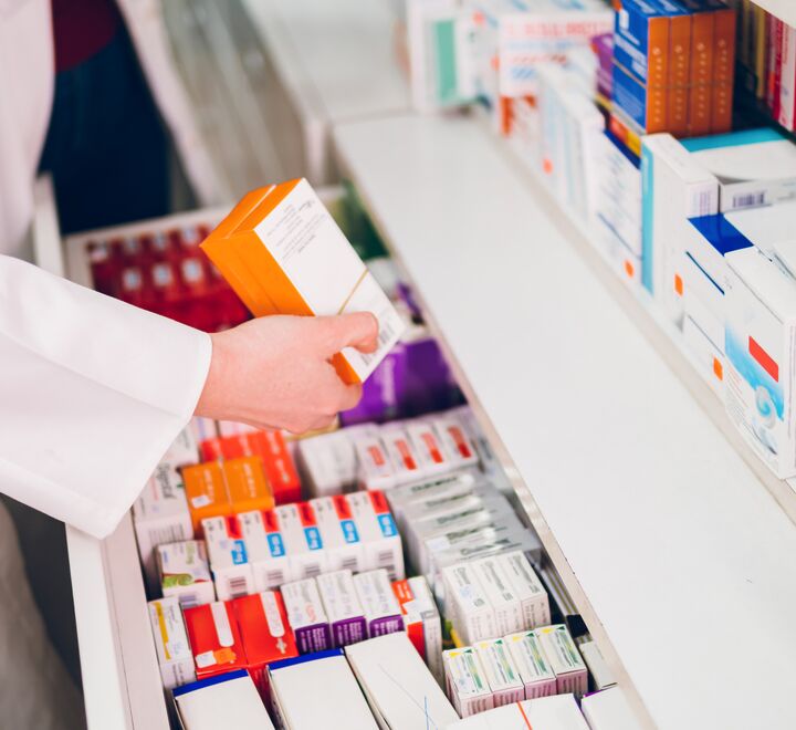 En farmasøyt sorterer legemidler på et apotek