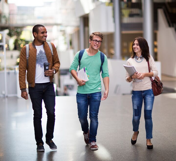 Smilende studenter som går gjennom campus Oslo