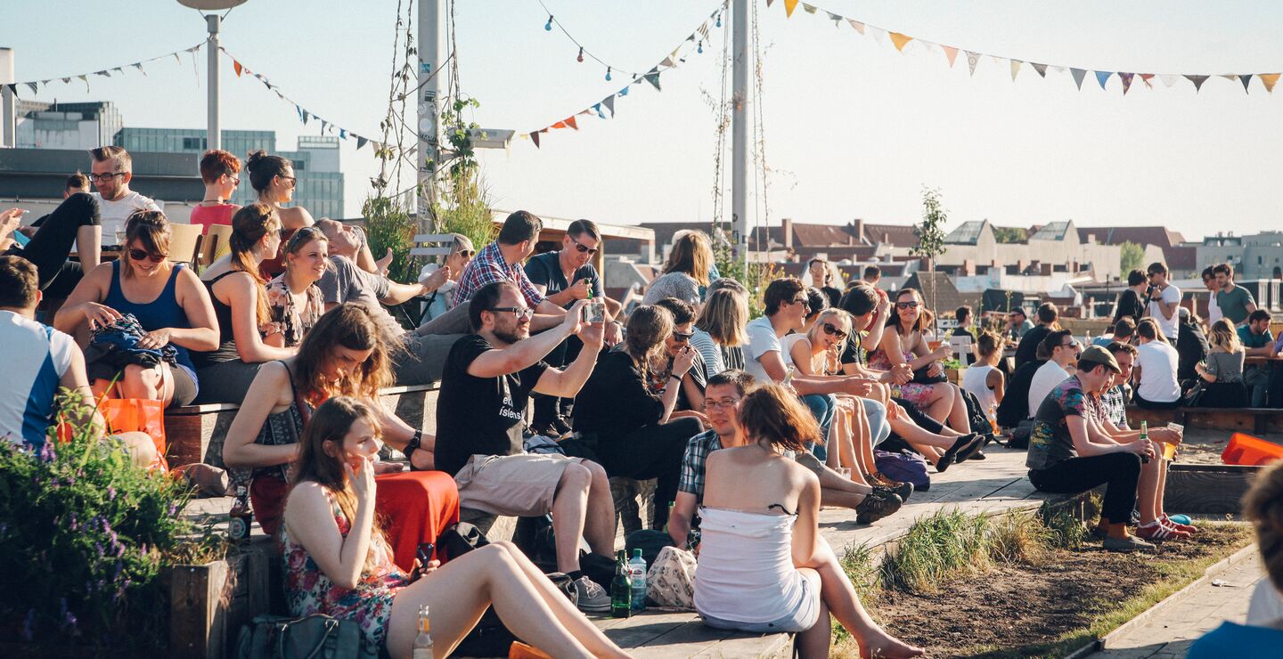 Samling med mennesker ute i en park som sosialiserer