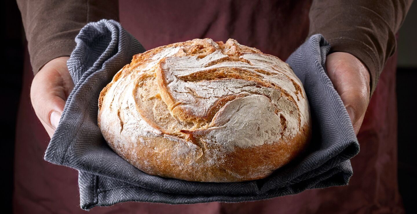 Freshly,Baked,Bread,In,Bakers,Hands