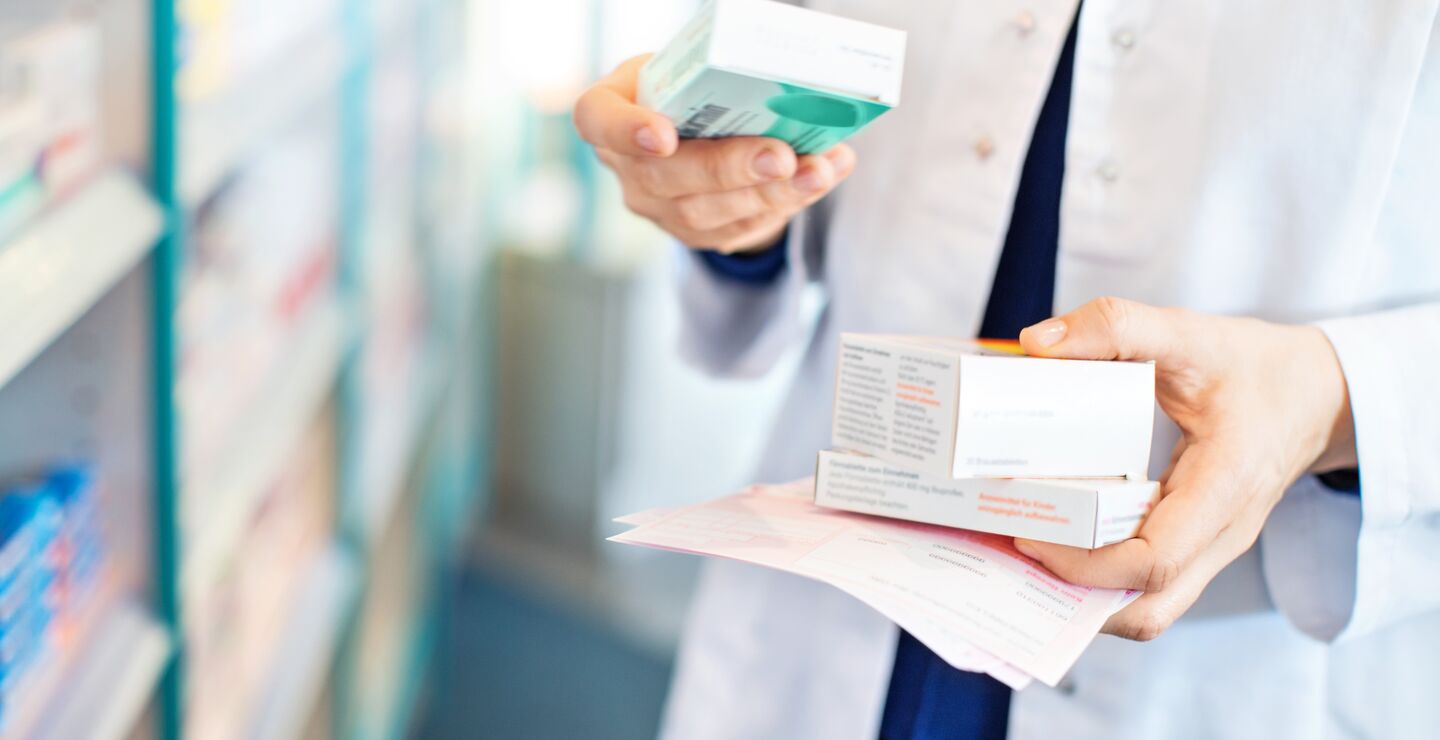 Illustration of medical worker holding packs of medicines