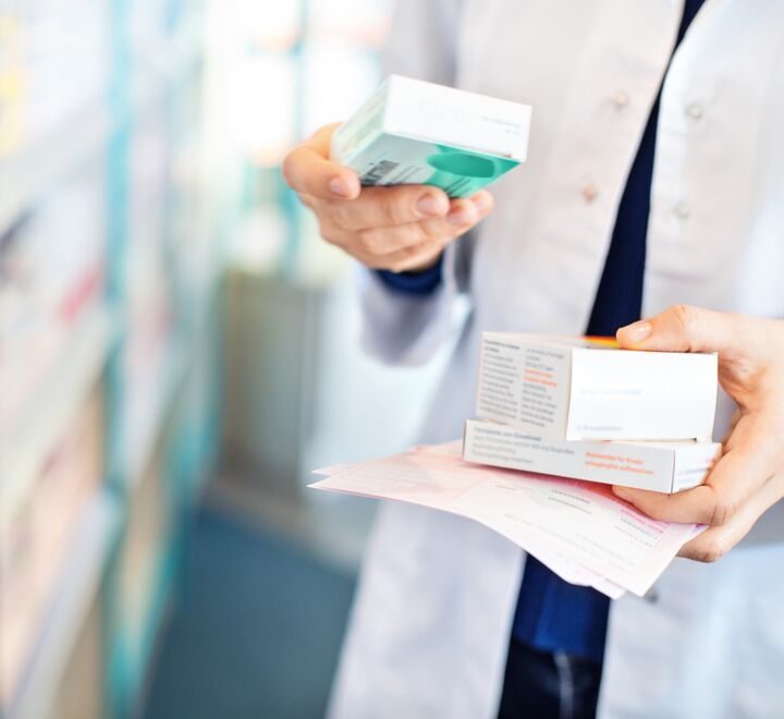Pharmacist's hands taking medicines from shelf