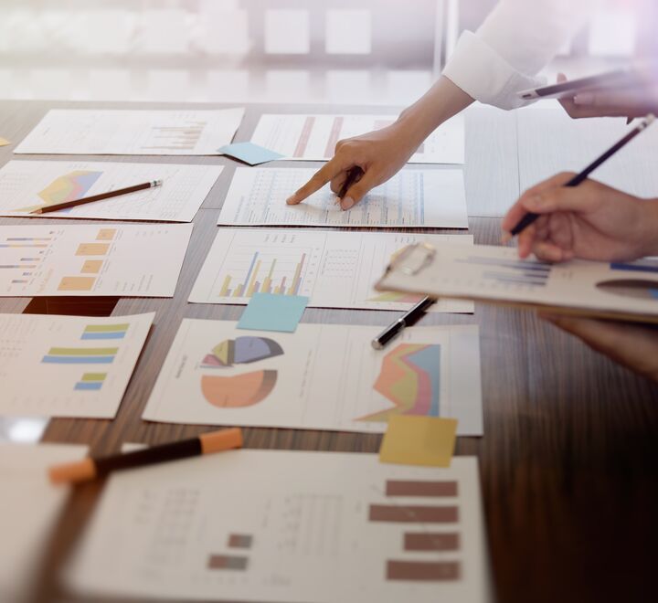 Hand pointing at a table full of documents