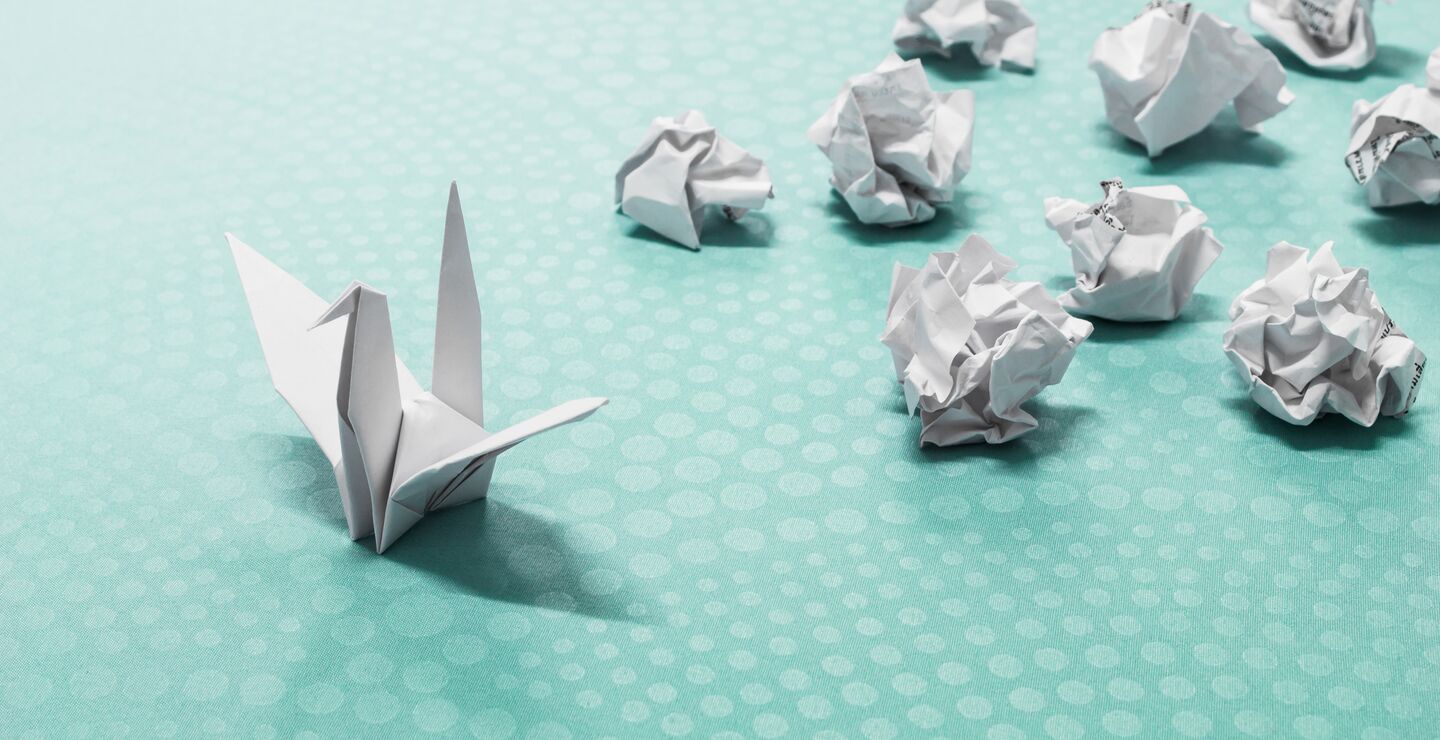 Origami av en svane sammen med mange baller krøllet papir