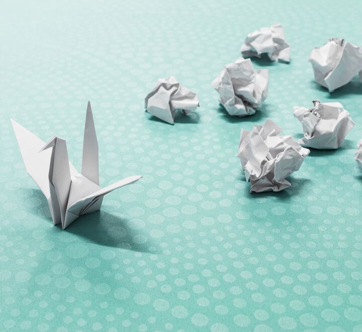 Origami av en svane sammen med mange baller krøllet papir