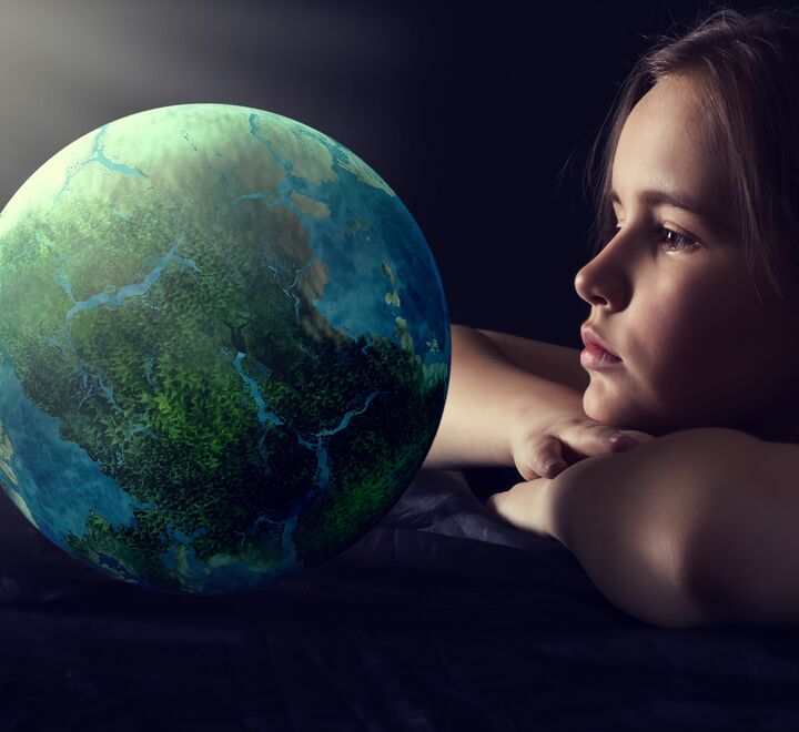 Ung jente som ser på en jordklode
