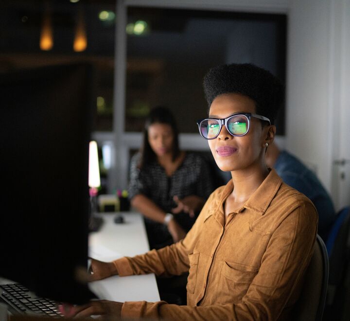 Bilde av en ung kvinne sittende foran en pc