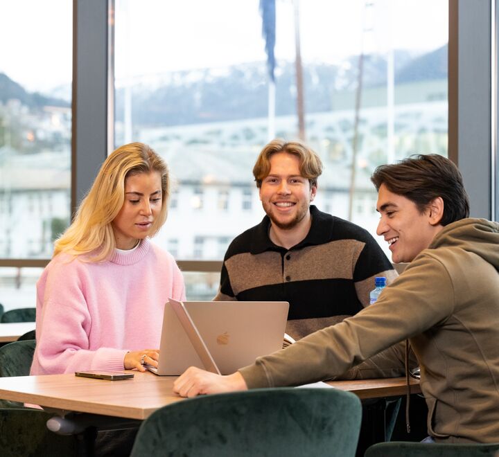 Three students sitting around a computer
