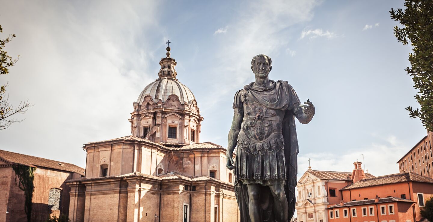 Julius Caesar statue med kirken Saint Luca e Martina i bakgrunnen.