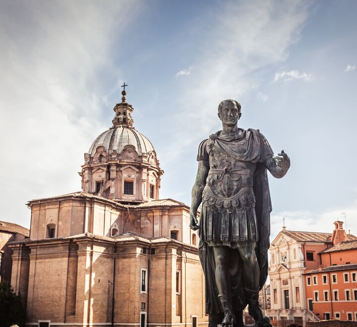 Julius Caesar statue med kirken Saint Luca e Martina i bakgrunnen.