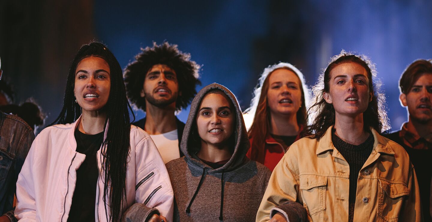 Gruppe med unge samlet på rekke i mørket