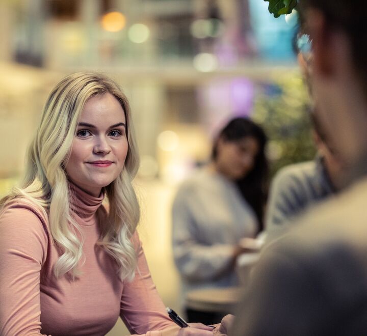 En kvinne som ser inn i kameraet