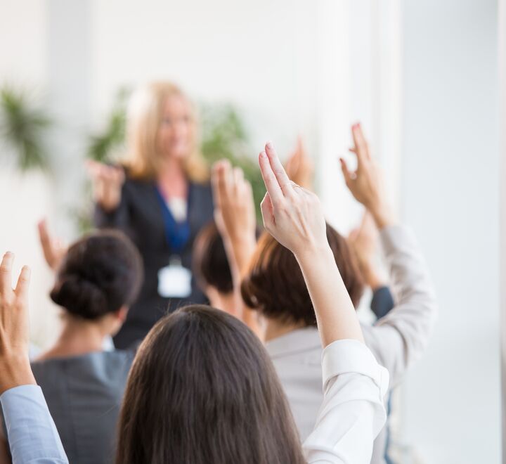 En mengde folk rekker opp hendene