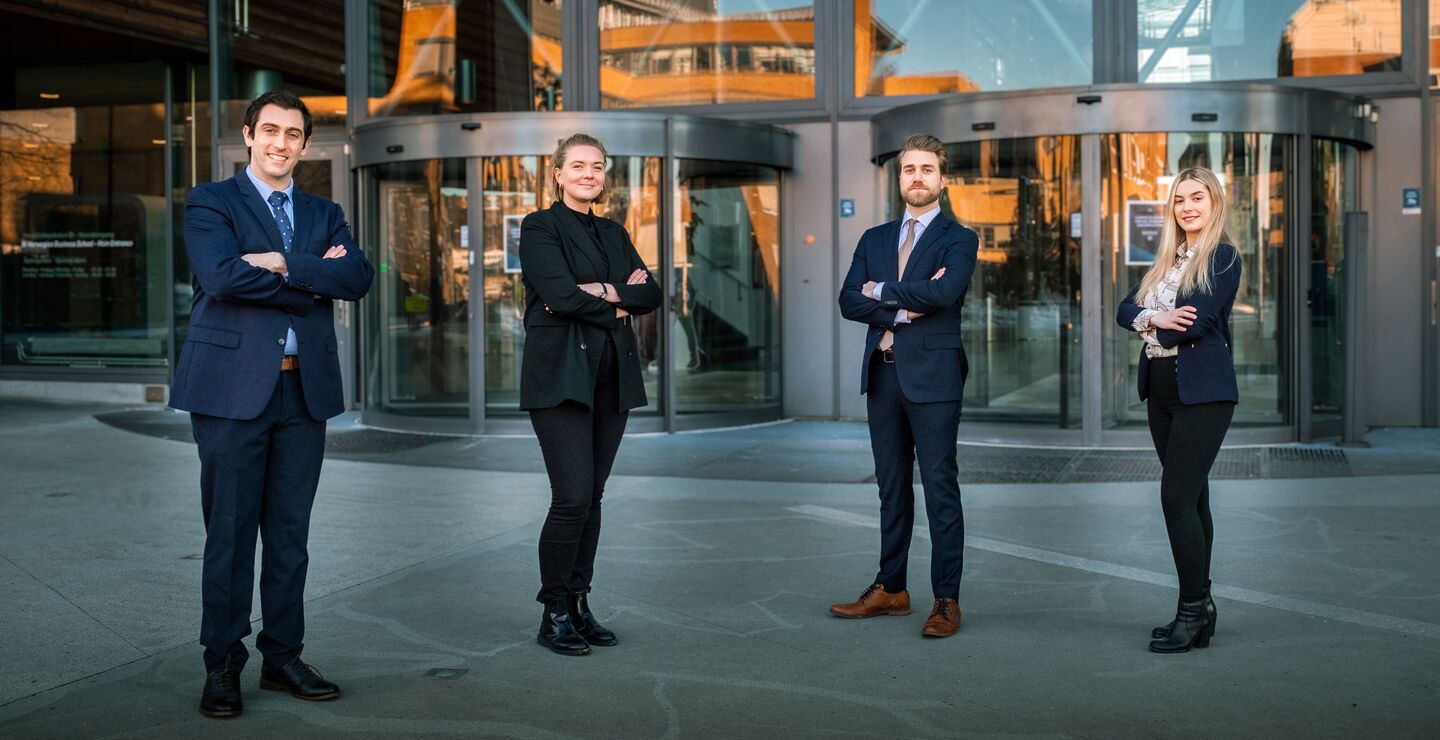 Fire personer som st&aring;r utenfor BI