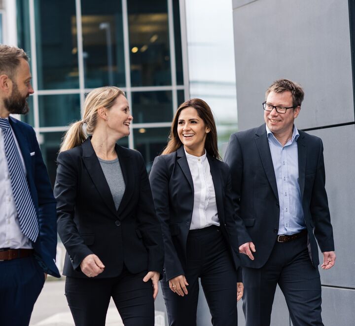 Fire pent kledde mennesker prater med hverandre og smiler