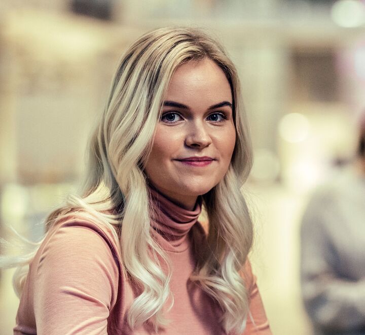 Bilde av ei blond kvinne på campus