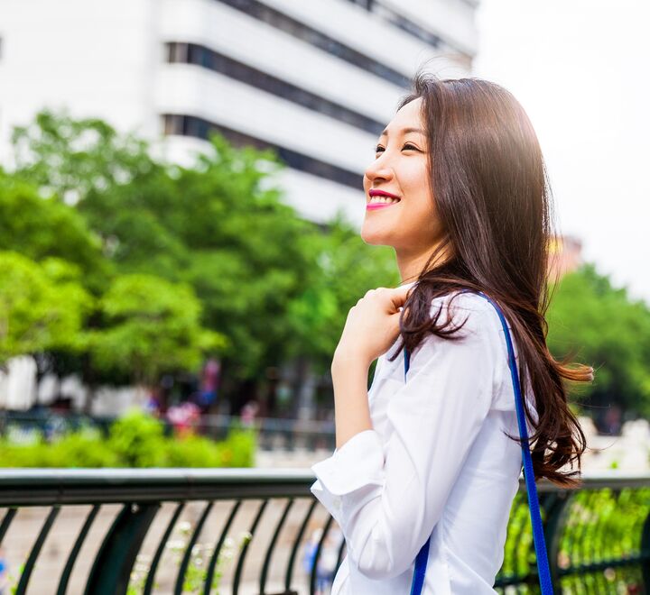 A woman smiling on a bridge