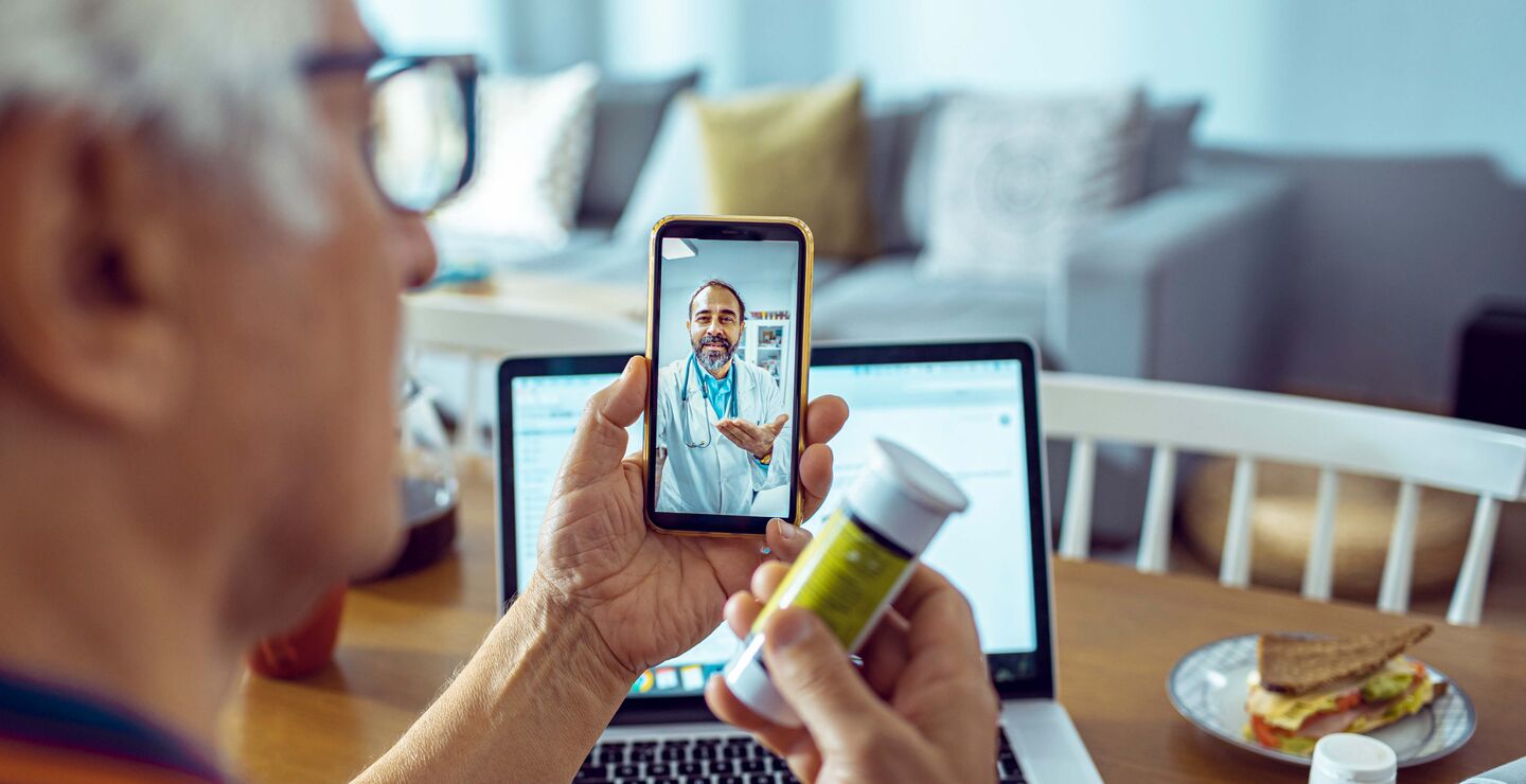 Eldre mann får digital hjemmeoppfølging av lege over mobil