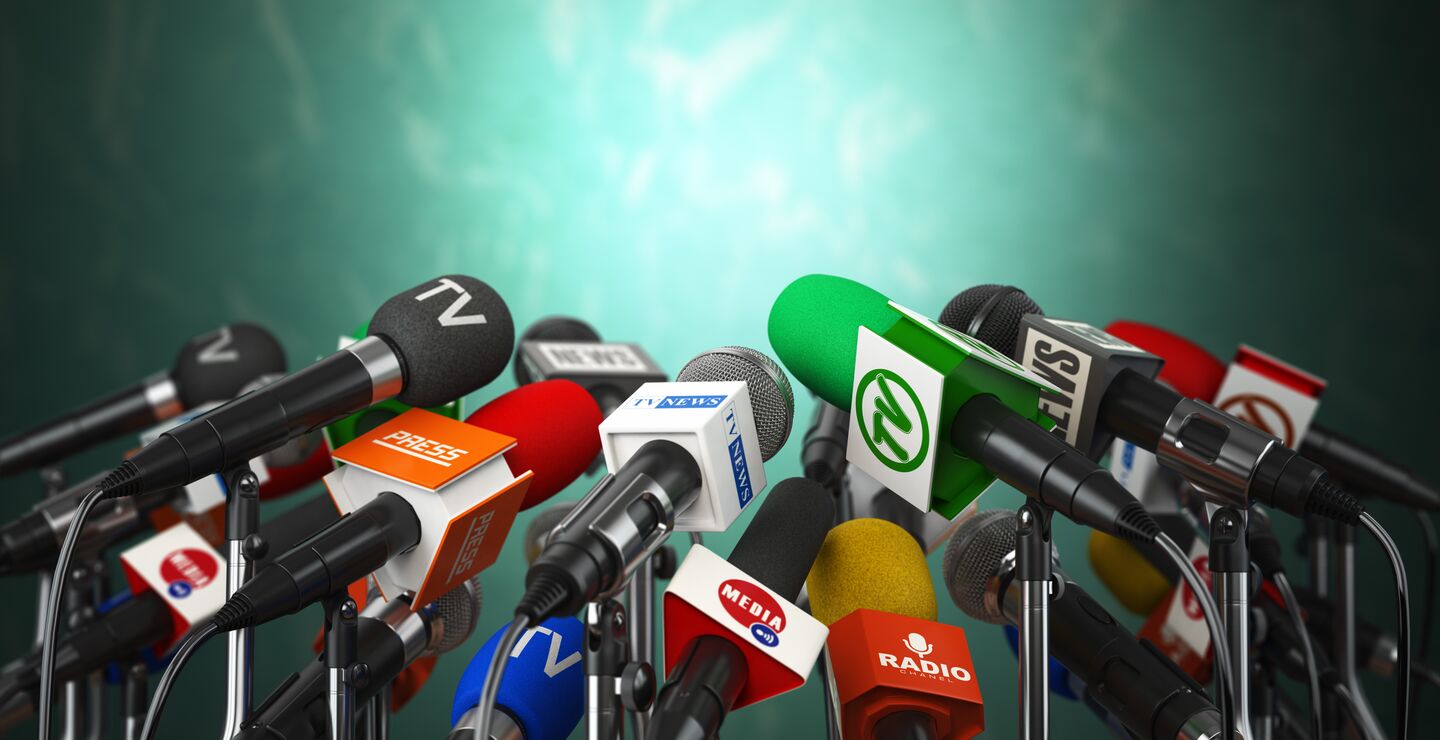 Bilde av mange mikrofoner fra ulike mediebyråer.