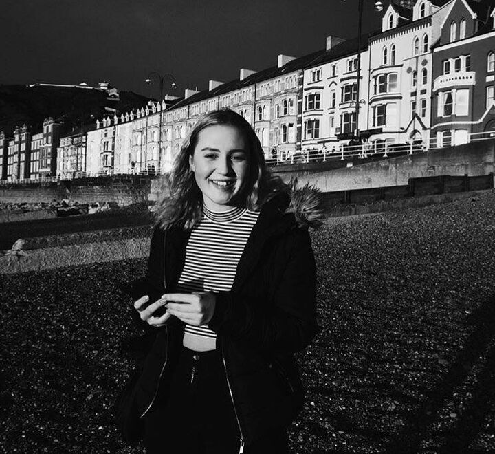 Grått hvitt bilde av student som smiler ute