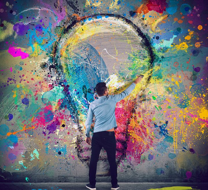 Bilde av en mann som maler med farger på en vegg