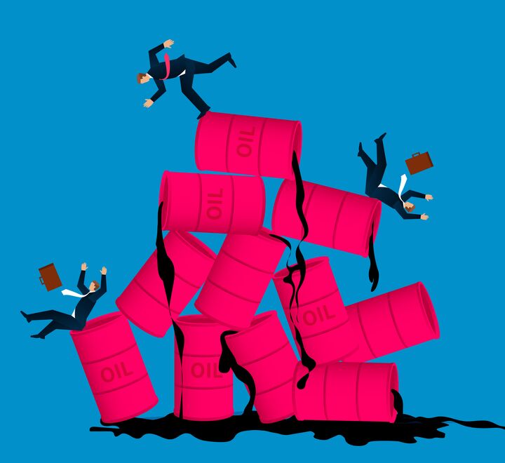 Business men tripping over oil barrels