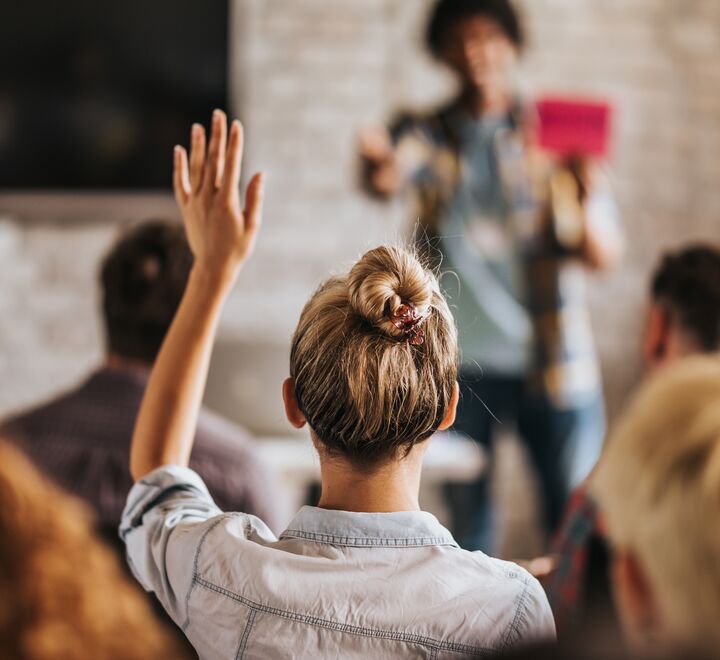 Woman raising her hand i a classroom