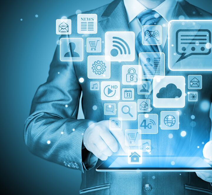 Mann som bruker et nettbrett hvor forskjellige apper flyr ut av nettbrettet