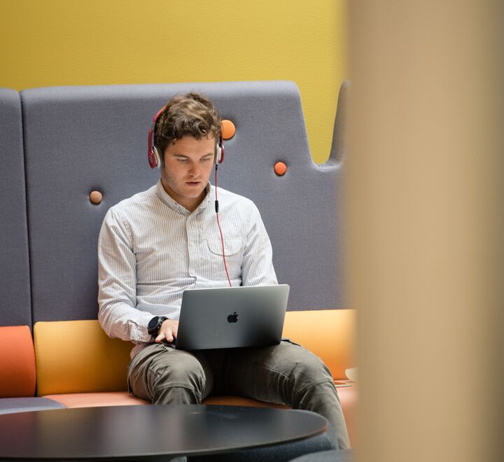 Young man with Mac and headphones