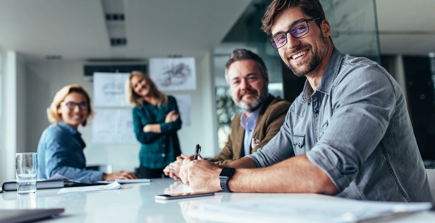 Smilende mennesker i møte