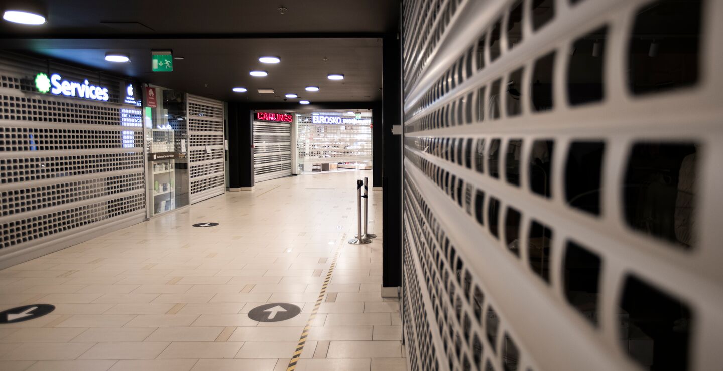 Bilde tatt inne i et tomt kjøpesenter med stengte butikker.