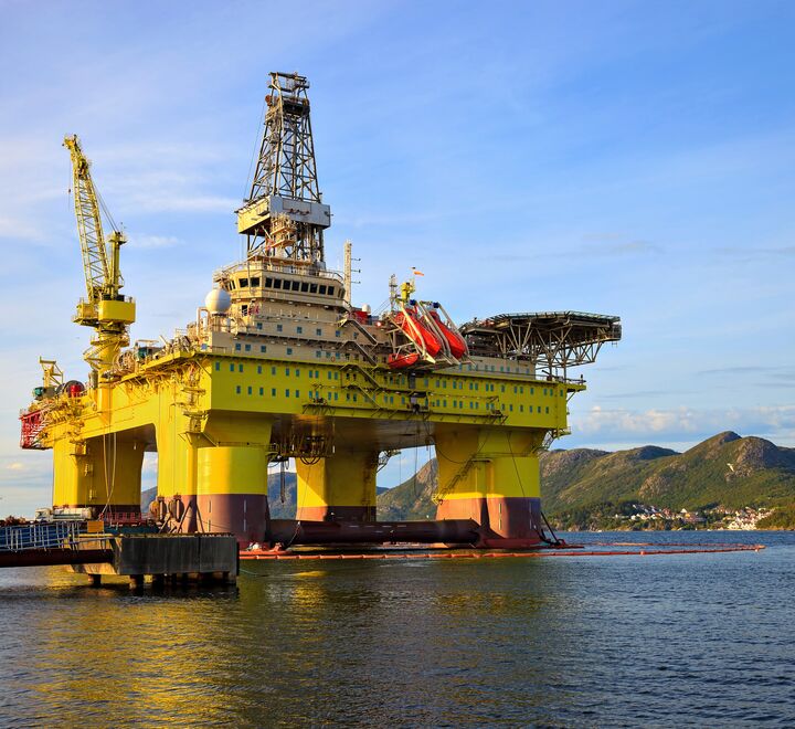 Skyldfølelsen siver også inn i oljeindustrien. Kronikkforfatterne argumenterer for at politikerne må gjennomføre sine djerve klimamål og komme ut av hykleriets grenseland. (Bilde av en oljerigg nære fjell i Norge. (Foto: Nightman).