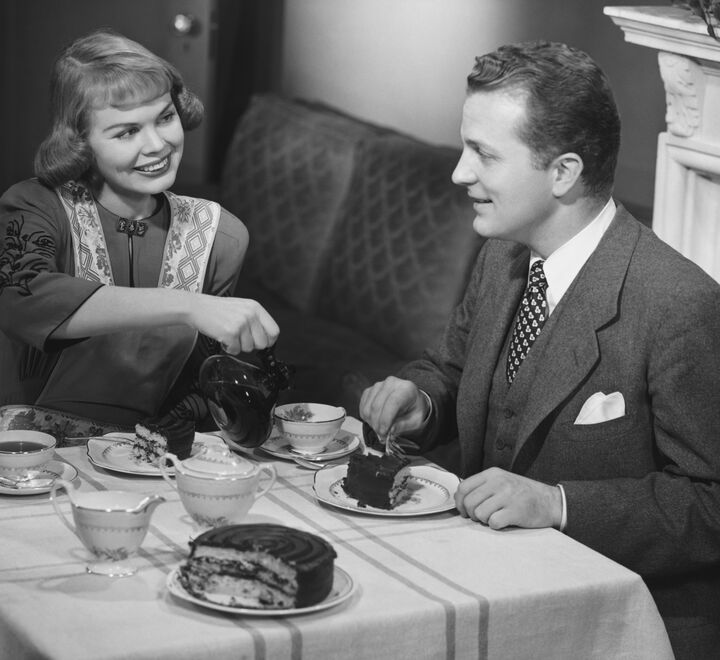 Historisk bilde: En husmor serverer sin mann te  ved spisebordet