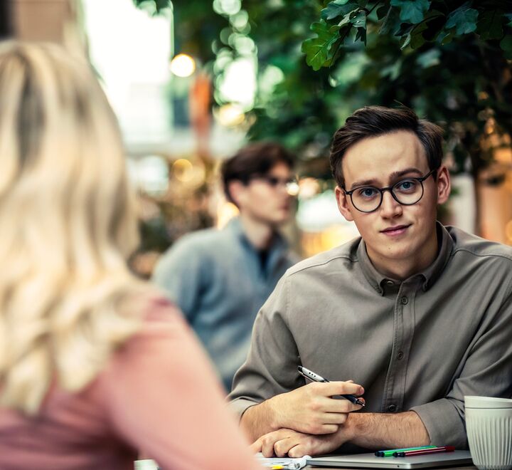 Spørrende student som ser på en annen student 
