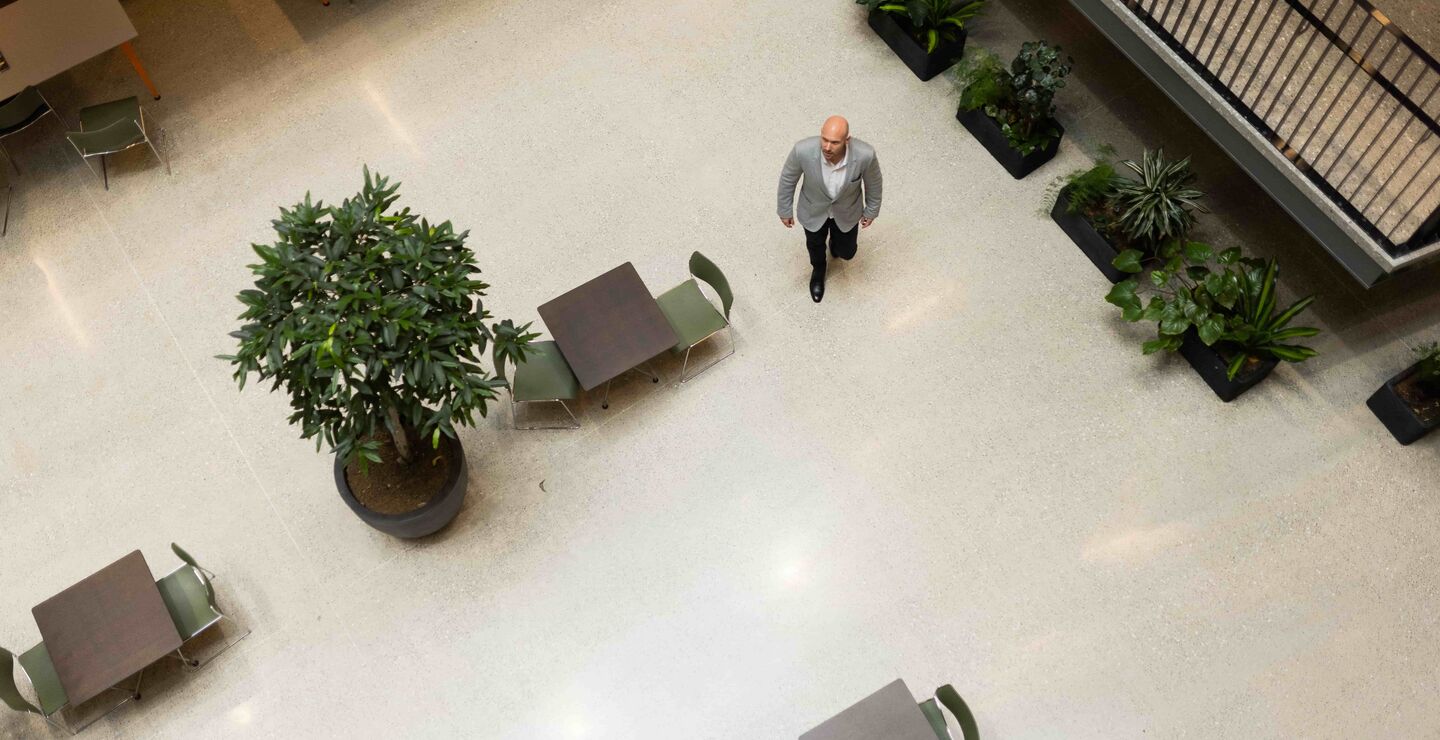 Bilde av Michael Mcneil oveifra som går bortover i en kantine