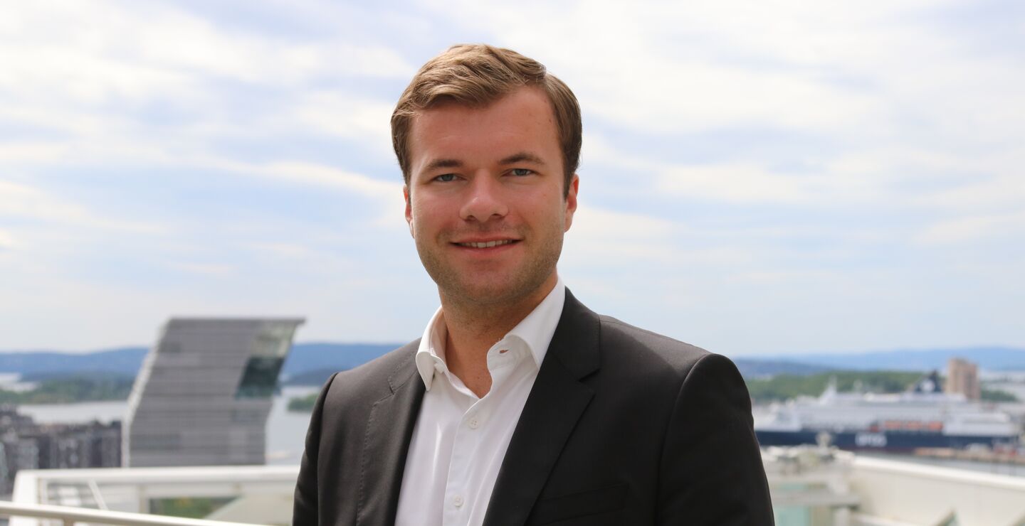 Profilbilde av Knut Mehl p&aring; en takterasse ved Oslo fjorden i dress