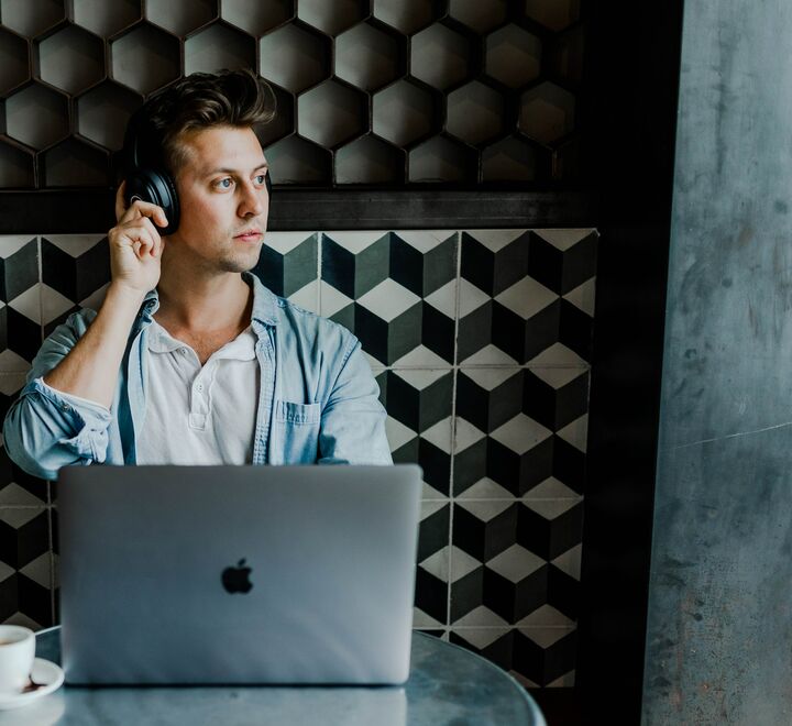 Mann med laptop og headset