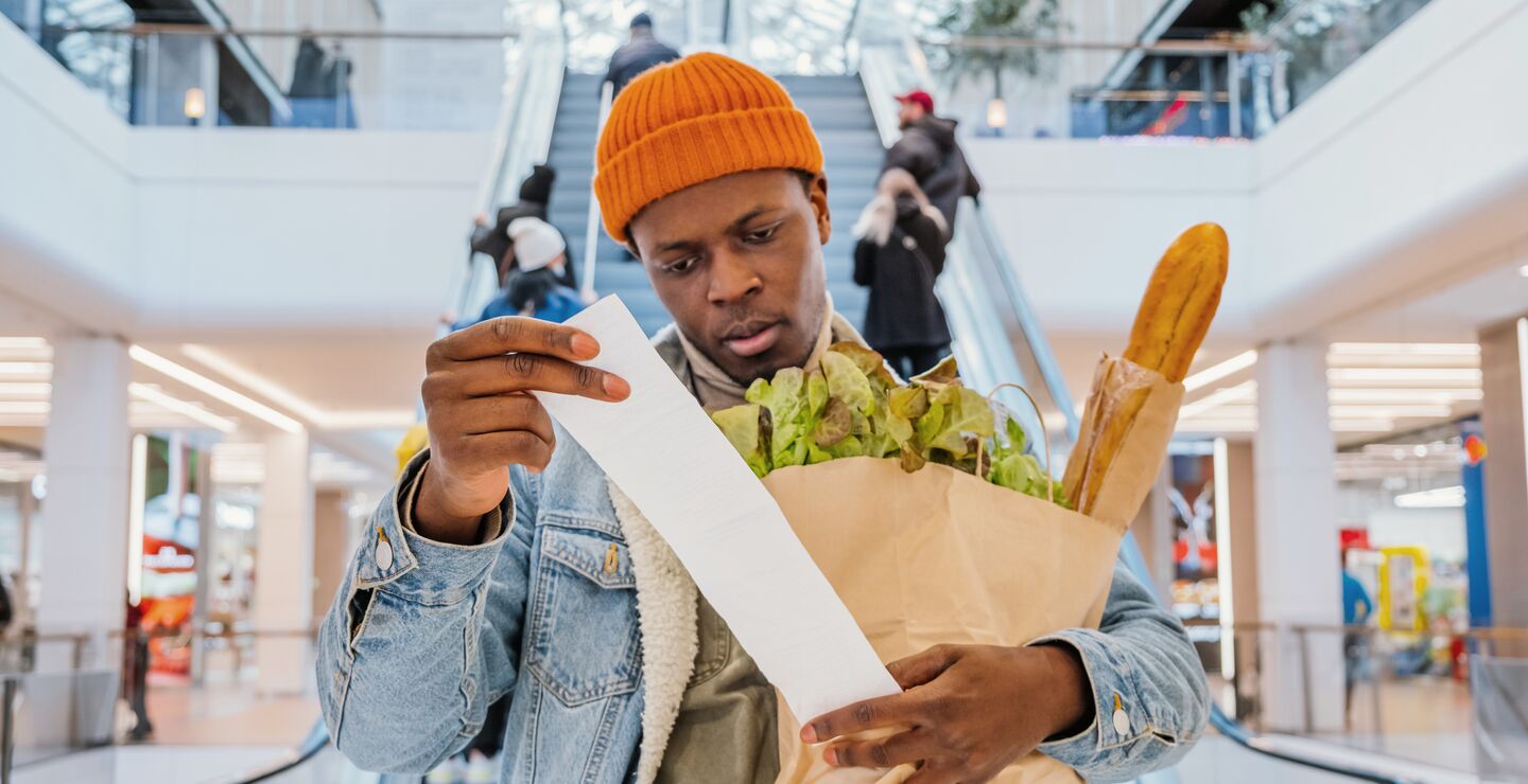 En mann undersøker kvitteringen sin på et kjøpesenter.