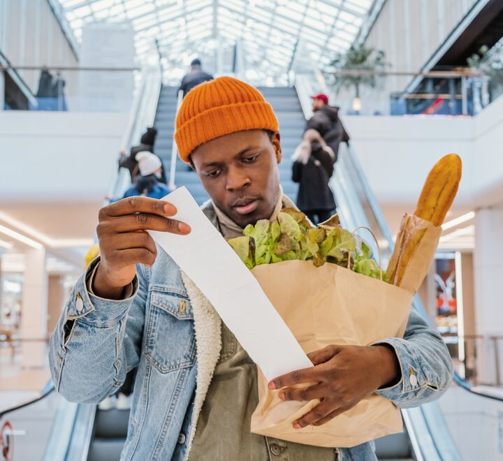 En mann undersøker kvitteringen sin på et kjøpesenter.