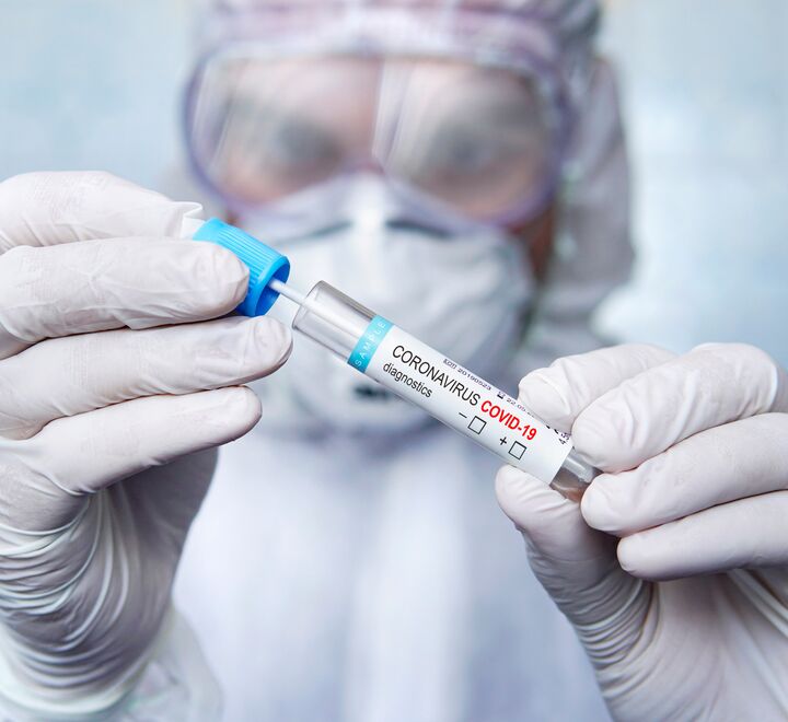 Sykepleier i verneutstyr med koronatest